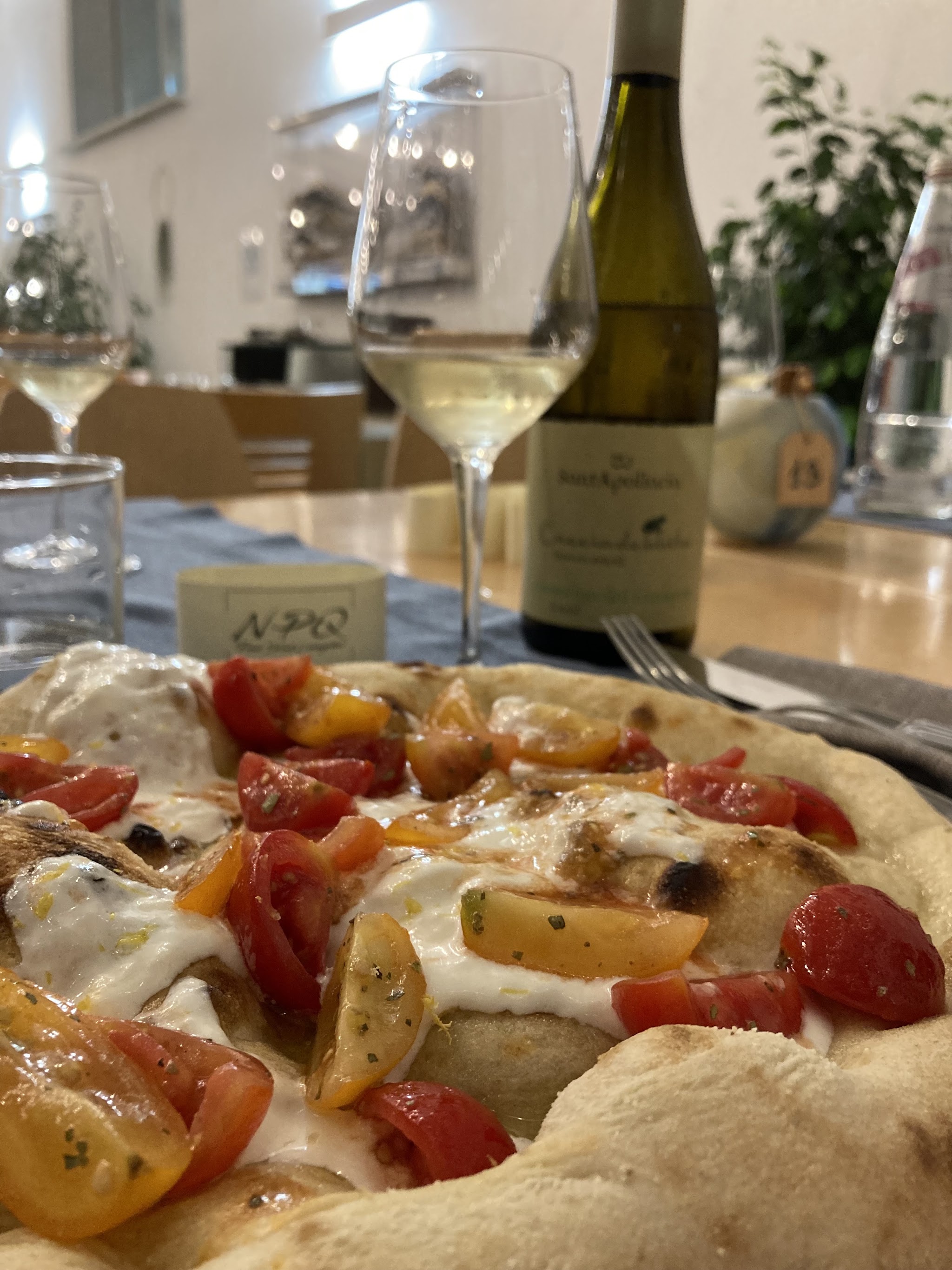 Pizza, vino e tavolo apparecchiato da NovePuntoQuattro